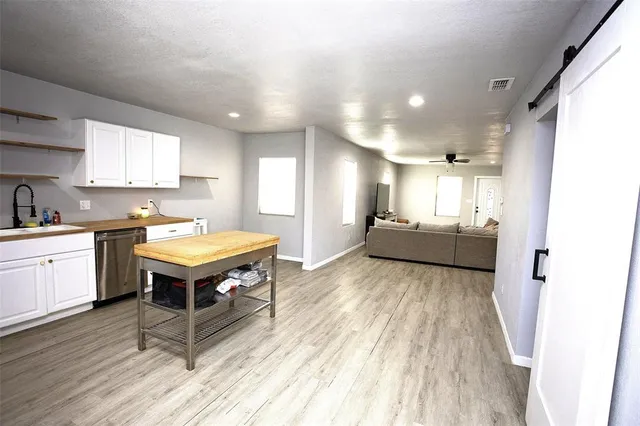 a living room with stainless steel appliances furniture stove and a kitchen view