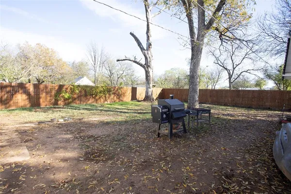 a view of a backyard with wooden fence