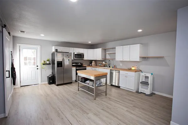 a kitchen with a wooden floor and a refrigerator