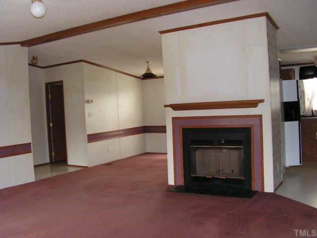 51 Kermit Duncan Road Timberlake, NC 27583 - Photo 4 of 6 a view of an empty room with a fireplace and a fan
