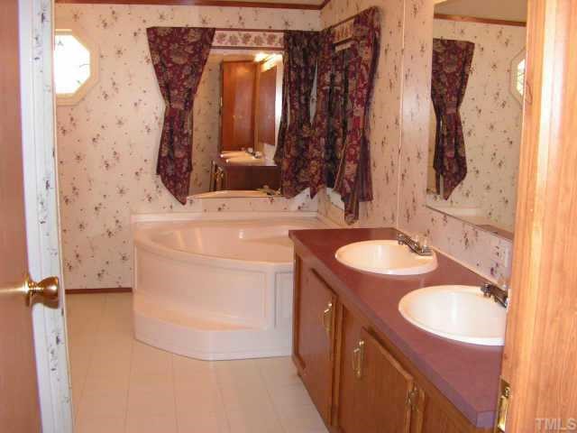 51 Kermit Duncan Road Timberlake, NC 27583 - Photo 6 of 6 a bathroom with a sink vanity mirror and shower