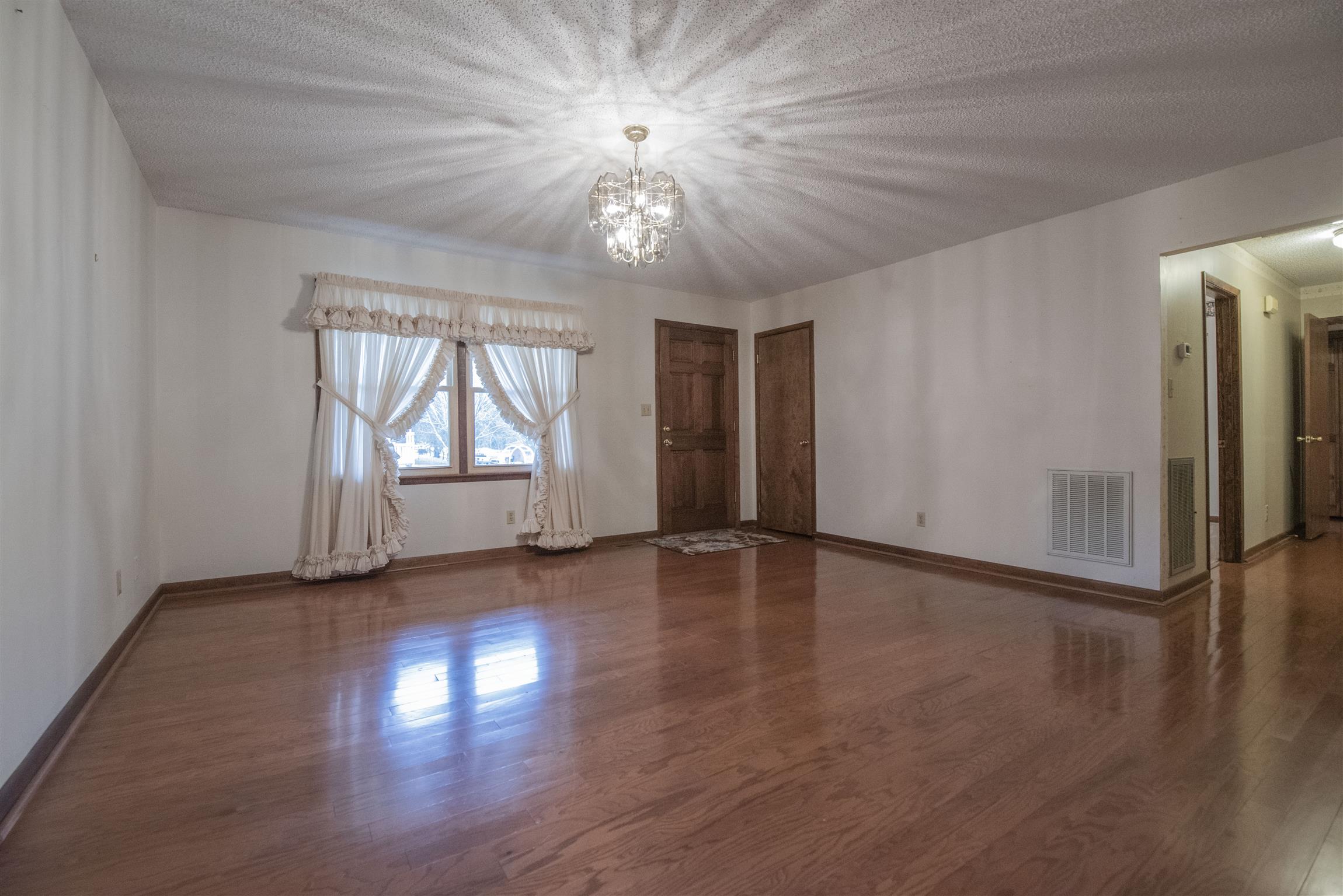 925 Alford Road Murfreesboro, TN 37129 - Photo 3 of 30 an empty room with wooden floor chandelier and windows