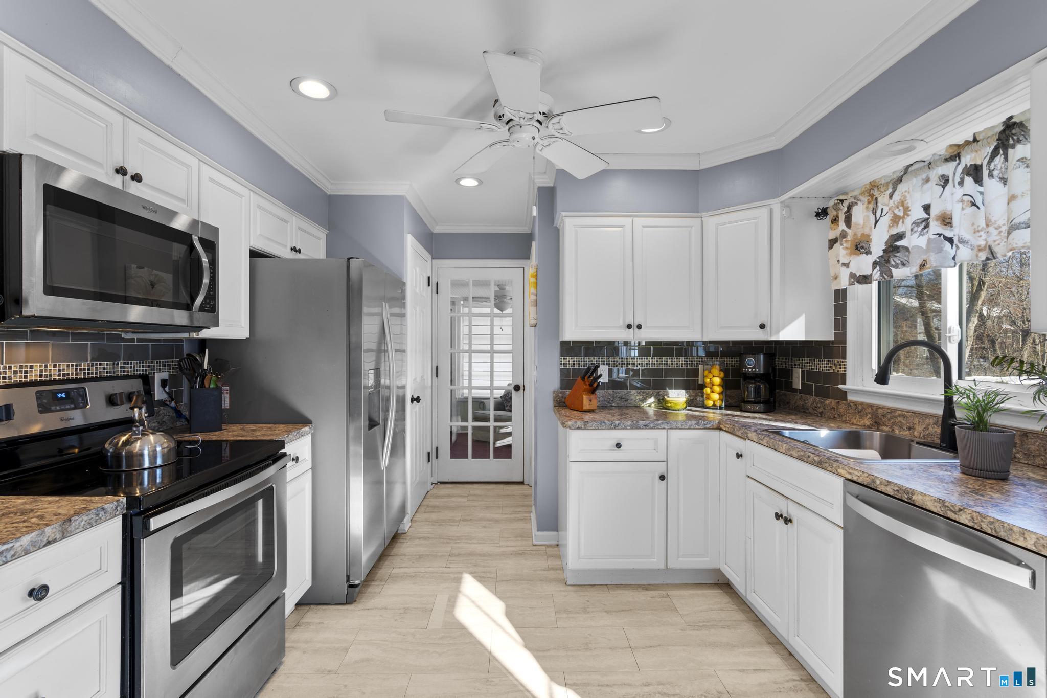 710 East Main Street Stratford, CT 06614 - Photo 7 of 34 a kitchen with stainless steel appliances granite countertop a refrigerator a sink dishwasher a stove oven and white cabinets with wooden floor