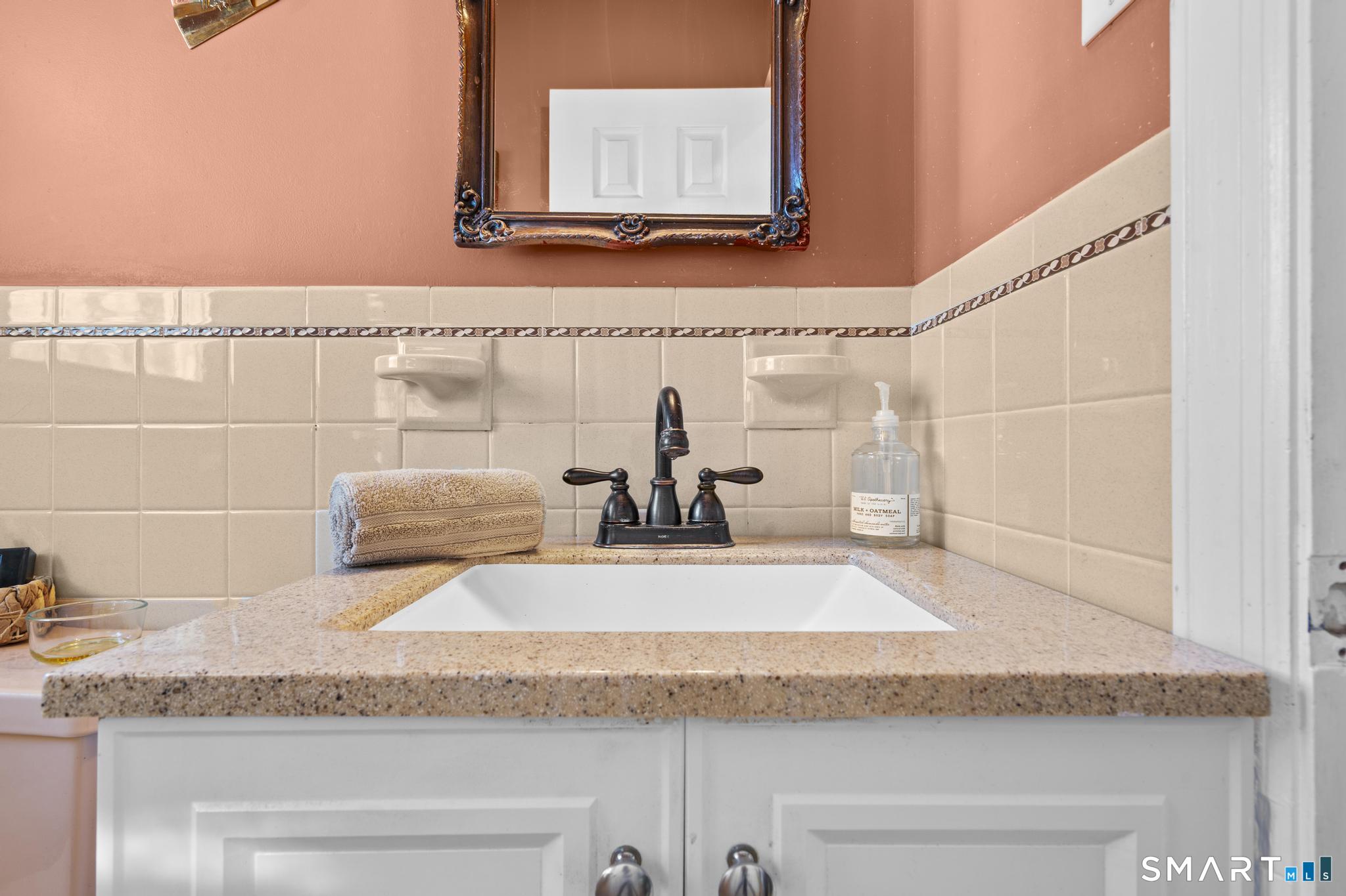 710 East Main Street Stratford, CT 06614 - Photo 8 of 34 a bathroom with a granite countertop sink and a mirror