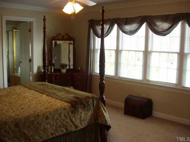 1613 Kendall Hill Road Willow Spring, NC 27592 - Photo 5 of 10 a bedroom with a bed mirror and window