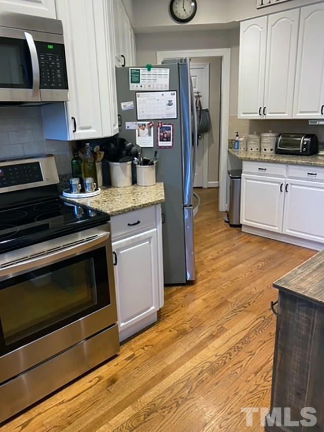 2017 Treverton Place Raleigh, NC 27609 - Photo 3 of 6 a kitchen with stainless steel appliances granite countertop a stove and a refrigerator
