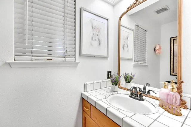 a bathroom with a granite countertop sink and a mirror
