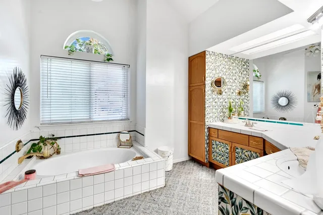 a bathroom with a tub a sink and a window