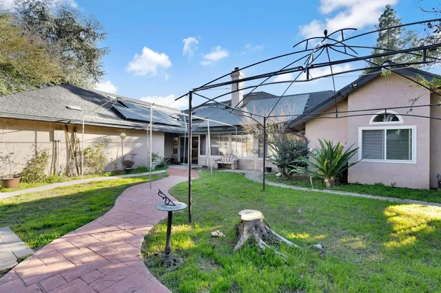 a view of a house with a backyard and a patio