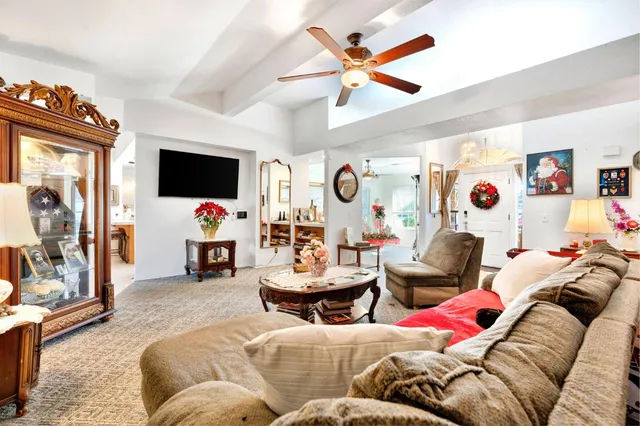 a living room with furniture a flat screen tv and a window