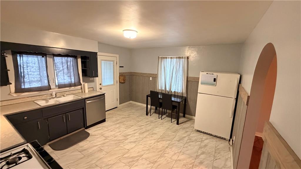 621 South Gosser Hill Road Leechburg, PA 15656 - Photo 6 of 15 a large kitchen with a refrigerator a stove a sink dishwasher and a dining table with wooden cabinet