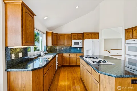 a kitchen with stainless steel appliances granite countertop a sink stove and refrigerator
