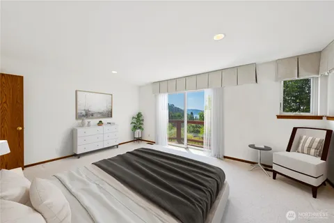 a spacious bedroom with a bed a couch and a window