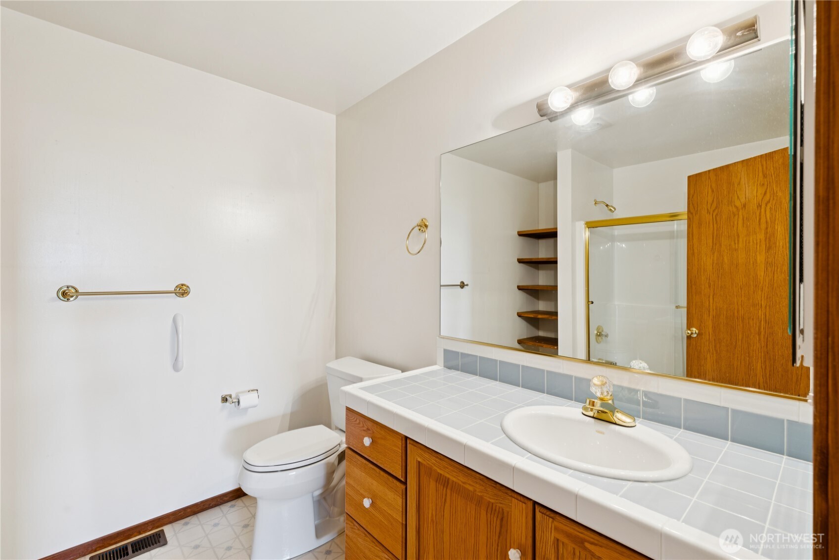 4158 Islander Way Anacortes, WA 98221 - Photo 32 of 40 a bathroom with a granite countertop sink toilet a large mirror and shower