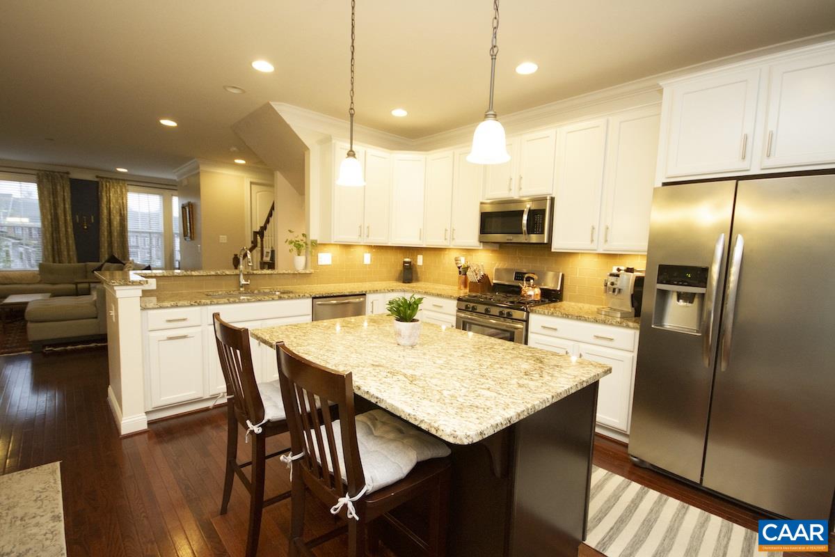 2122 Avinity Loop Charlottesville, VA 22902 - Photo 14 of 27 a kitchen with stainless steel appliances granite countertop a refrigerator a stove a sink a dining table and chairs with wooden floor