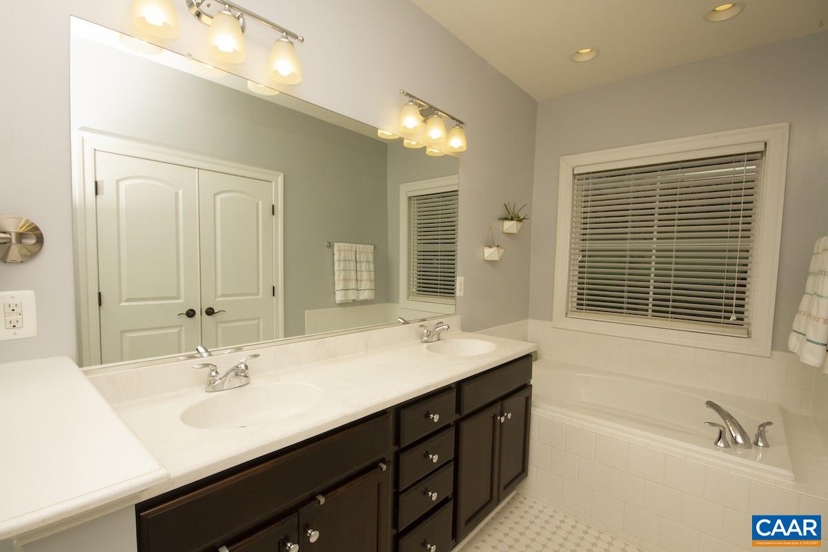 2122 Avinity Loop Charlottesville, VA 22902 - Photo 19 of 27 a bathroom with a double vanity sink large mirror and a bathtub