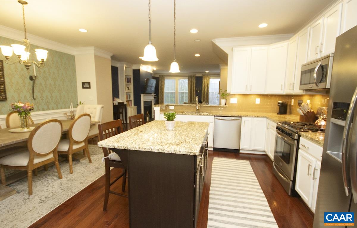 2122 Avinity Loop Charlottesville, VA 22902 - Photo 2 of 27 a large kitchen with granite countertop lots of counter space dining table and stainless steel appliances