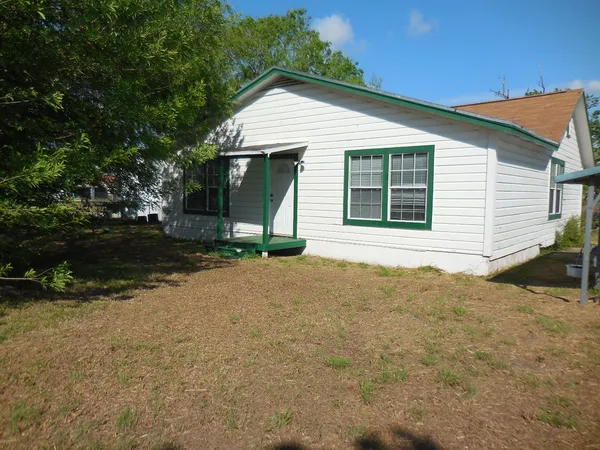 a view of a house with backyard and garden
