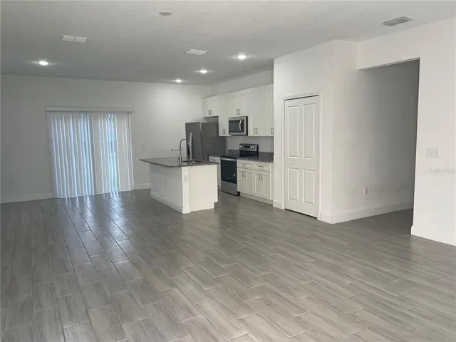 a view of kitchen with wooden floor and electronic appliances