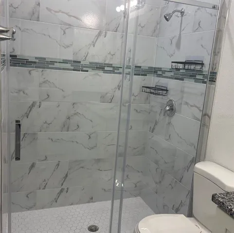 a bathroom with a toilet and a shower