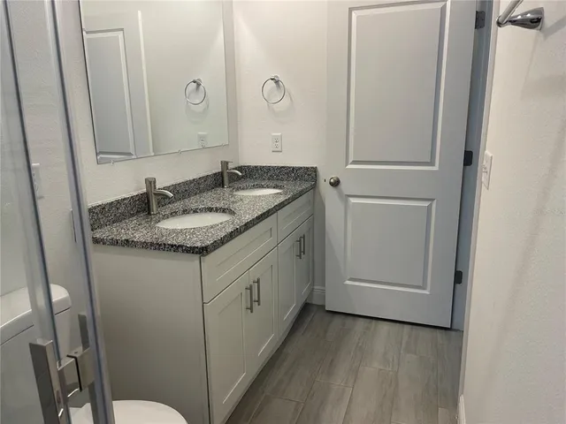 a bathroom with a granite countertop sink and a mirror