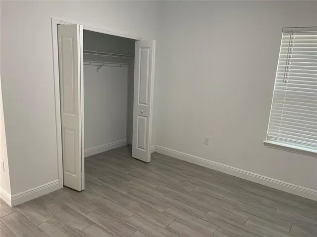 an empty room with wooden floor and closet
