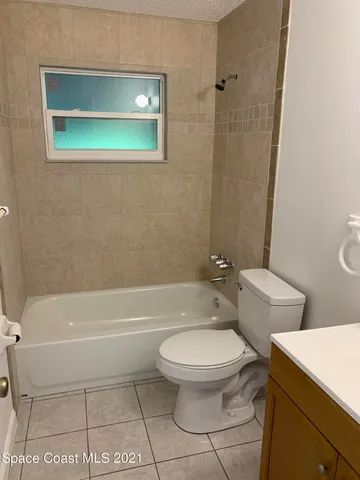 a white toilet and tub sitting next to a bathroom sink