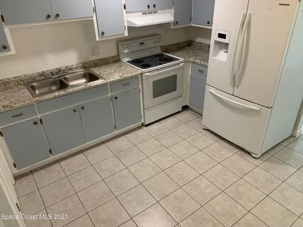 a kitchen with white cabinets and white appliances