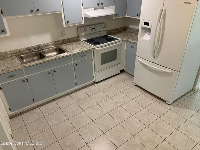 a kitchen with white cabinets and white appliances