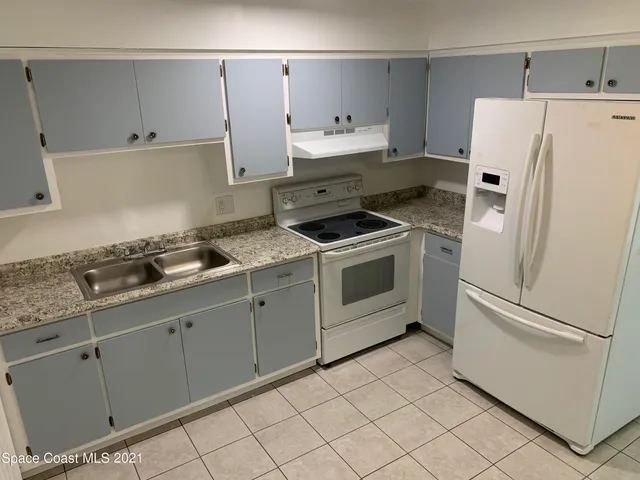 a kitchen with granite countertop cabinets and white appliances