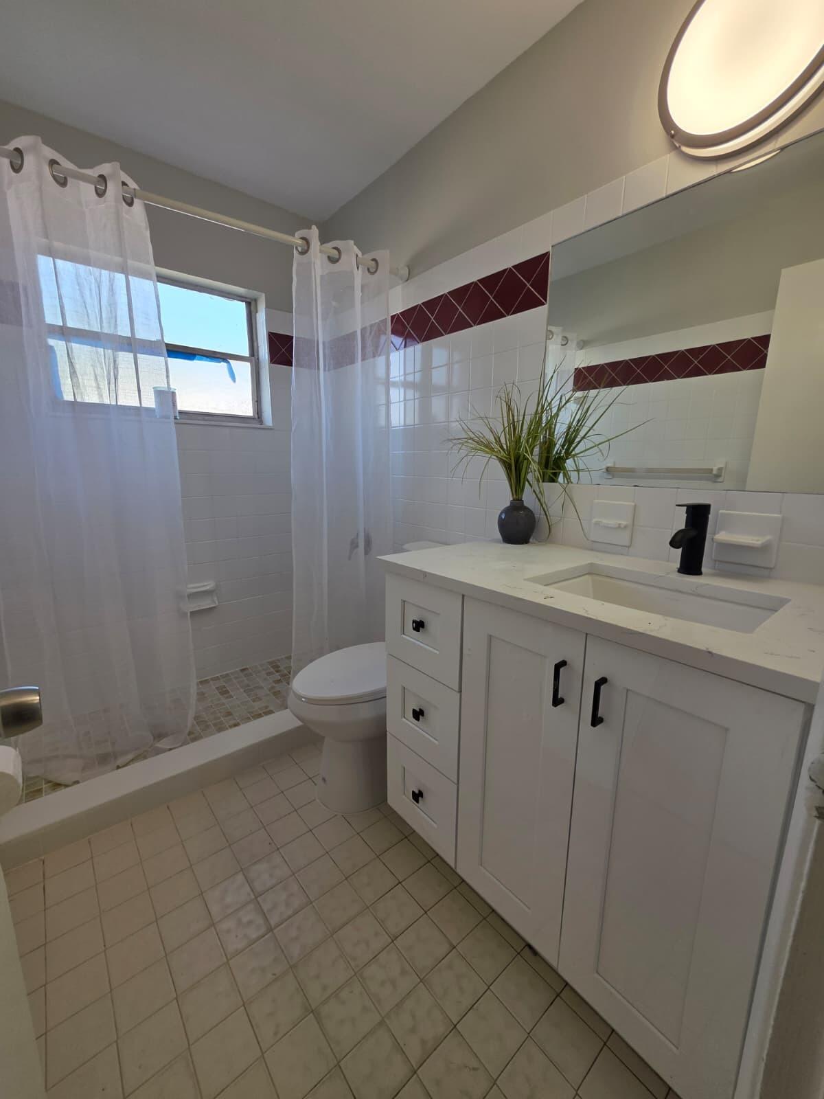 3386 Rudolph Road Lake Worth Beach, FL 33461 - Photo 16 of 25 a bathroom with a double vanity sink a toilet and a mirror