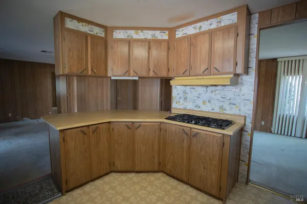 a kitchen with a stove a refrigerator and cabinets