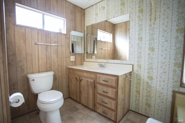 a bathroom with a toilet sink and mirror