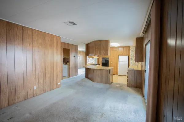 a view of a kitchen with refrigerator and a sink