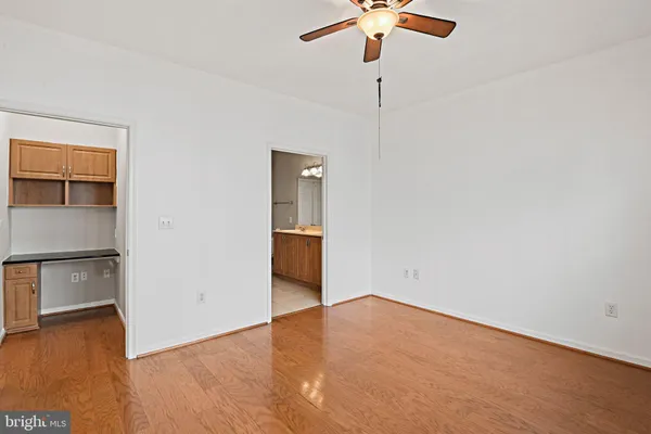 a view of empty room with wooden floor and window