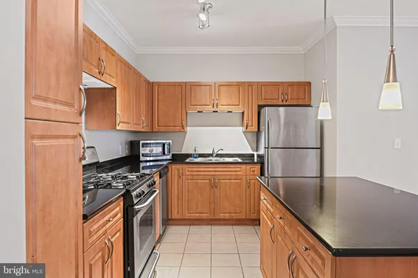 a kitchen with granite countertop a refrigerator stove top oven and sink