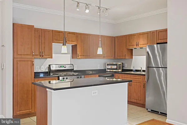 a kitchen with stainless steel appliances granite countertop a refrigerator a stove a sink dishwasher and a refrigerator
