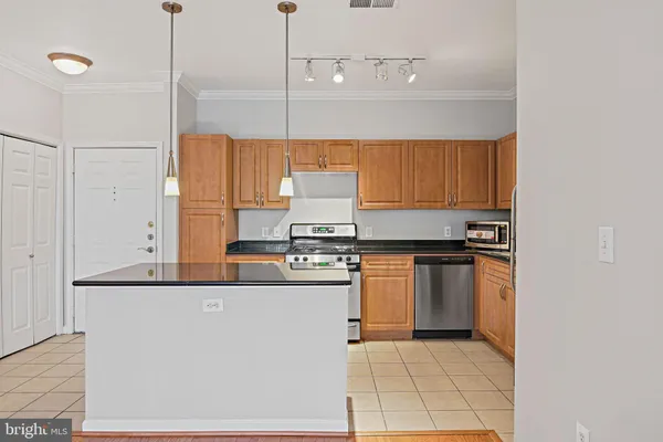 a kitchen with stainless steel appliances granite countertop a sink a stove and a refrigerator