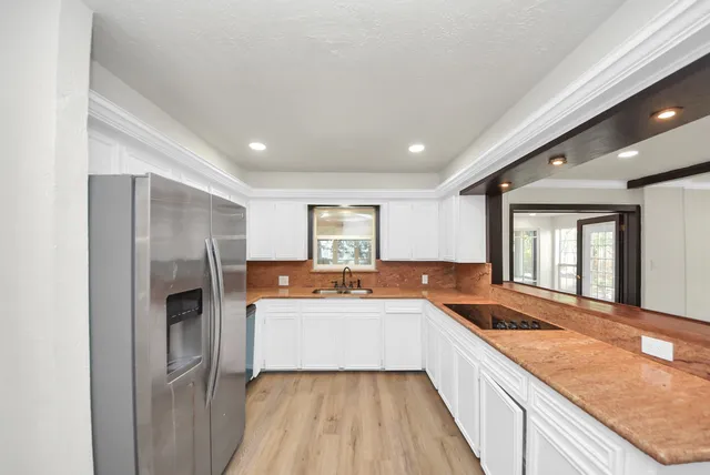 a large kitchen with a sink and cabinets