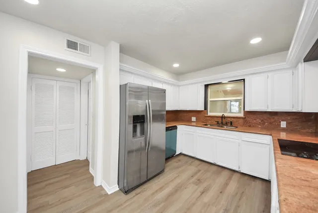 a kitchen with stainless steel appliances a refrigerator and a stove top oven