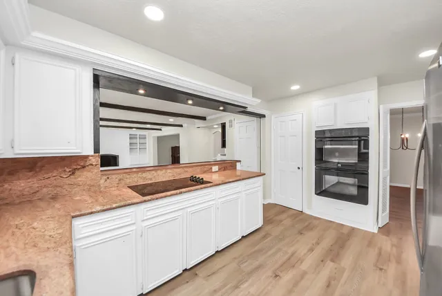 a kitchen with stainless steel appliances granite countertop a refrigerator and a stove
