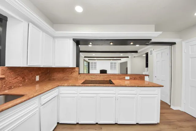 a kitchen with stove a sink and dishwasher with wooden floor