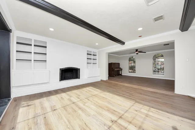 a view of an empty room with a fireplace and a window