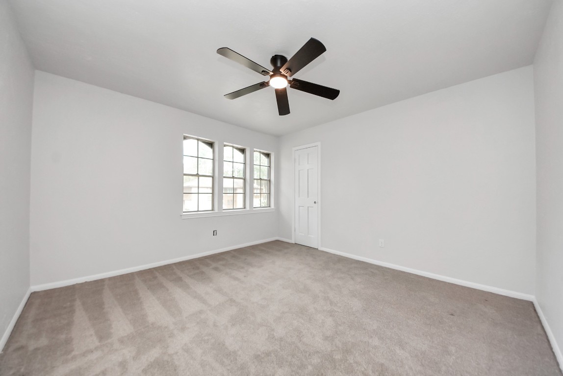 8111 Oak Moss Drive Spring, TX 77379 - Photo 34 of 49 a view of an empty room with a ceiling fan and window
