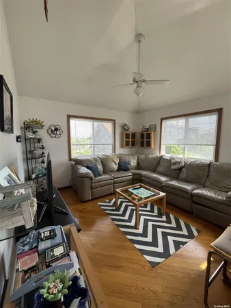 a living room with furniture kitchen view and a window