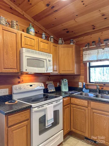 a kitchen with stainless steel appliances granite countertop a sink stove and cabinets