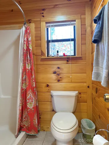 a bathroom with a toilet and a shower curtain