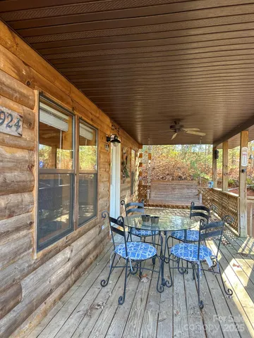 a view of a patio with table and chairs with wooden floor and floor to ceiling window