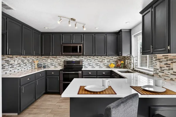 a kitchen with granite countertop a sink stove and cabinets