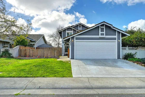a view of backyard of house with wooden fence